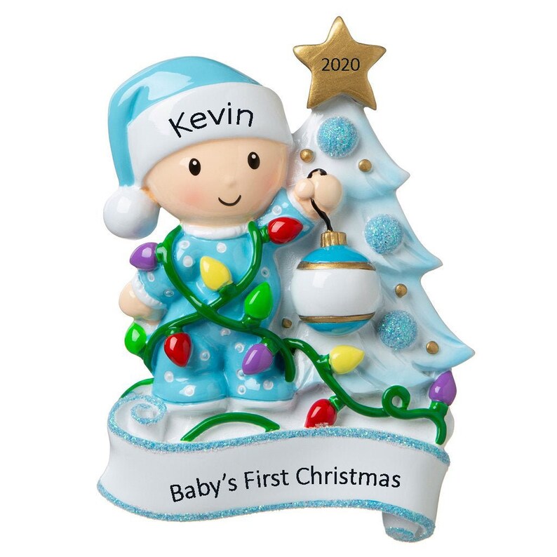 May include: A blue and white Christmas ornament featuring a baby boy in a blue sleeper holding a blue and white ornament. The ornament is decorated with a string of colorful lights and the text "Kevin" and "Baby's First Christmas". The ornament also features a small white star with the year "2020" on it.