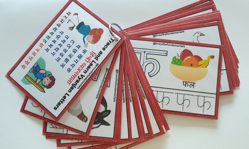 May include: A set of red and white flashcards with a tracing activity for learning the Hindi alphabet. The cards feature a picture of a fruit bowl with the word "फल" (meaning "fruit") written below. The Hindi letter "फ" is shown with dotted lines for tracing.