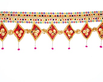 May include: A red and gold decorative door hanging with a beaded border and pink tassels. The hanging features a repeating pattern of diamond shapes with gold accents.
