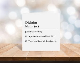 May include: A square white greeting card featuring black printed text that defines the word Dicktim as a noun, specifically a Dickhead-Victim, with two numbered points describing a person who acts like a jerk and then plays the victim.