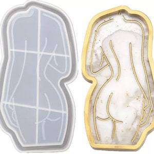 May include: Two decorative trays. One is a clear, body-shaped mold with grid lines. The other is a gold-edged tray with a white and gold marbled design, featuring a gold outline of a body. Both are in a body shape.