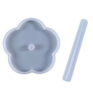 Peut inclure: Un moule en silicone bleu clair en forme de fleur avec un trou central et une paille cylindrique transparente séparée. Le moule a une surface lisse et est conçu pour le bricolage. Les articles sont sur fond blanc.