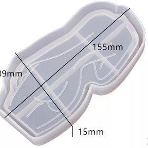 May include: A clear, rectangular silicone mold with rounded edges, designed for crafting. The mold measures 155mm long, 89mm wide, and 15mm deep. The weight is 45g. The mold has a unique shape with internal dividers.