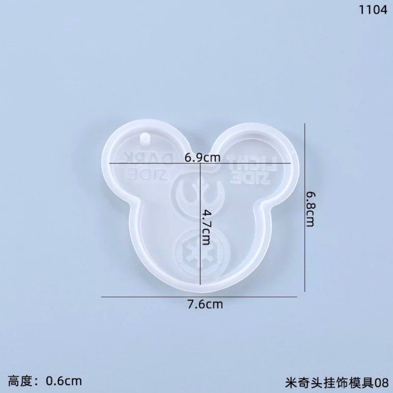 May include: A clear, Mickey Mouse-shaped silicone mold for crafting. The mold measures 7.6 cm wide, 6.8 cm high, and 0.6 cm thick. The design includes the text "ZIDE" and other graphic elements.