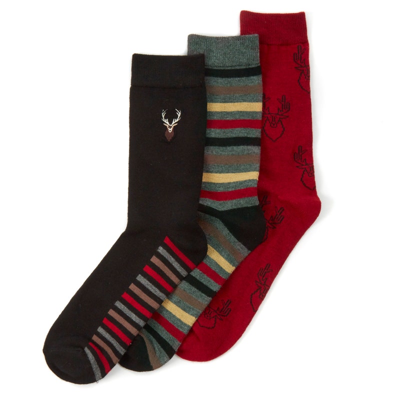 May include: Three pairs of socks with different patterns. One pair is black with a red, white and brown striped pattern on the ankle. Another pair is red with a black and white deer pattern. The last pair is grey with red, white and brown stripes.