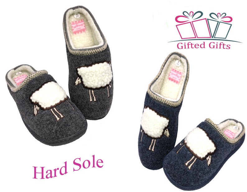 May include: Two pairs of gray wool slippers with a sheep design. The slippers have a hard sole and a fluffy white sheep embroidered on the front. The slippers are labeled "Gifted Gifts" and "Hard Sole".