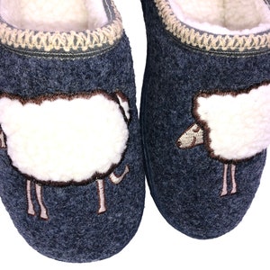 May include: A pair of gray wool slippers with a white sheep embroidered on each slipper. The sheep are facing opposite directions.