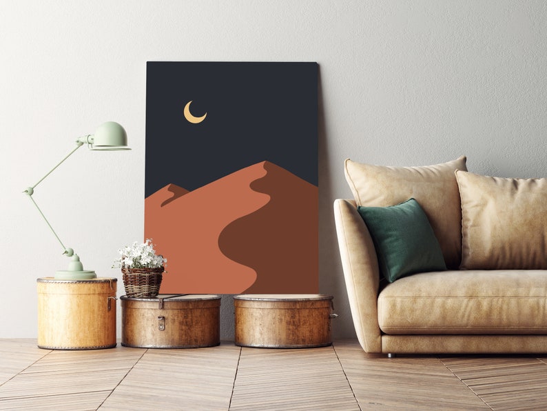 May include: A digital art print of a desert landscape with a crescent moon in the night sky. The print features a minimalist design with a dark blue background and a reddish-brown sand dune.