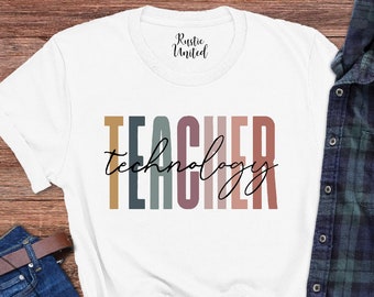 May include: White t-shirt with the text "TEACHER technology" in colorful, vertical stripes. The shirt is laid flat on a wooden surface with a pair of jeans, sunglasses, and a plaid shirt.