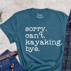 May include: A teal blue t-shirt with the text "sorry. can't. kayaking. bye." printed in white.