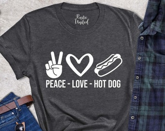 May include: A dark grey t-shirt with a white peace sign, heart, and hot dog graphic. The text "Peace - Love - Hot Dog" is printed below the graphic.