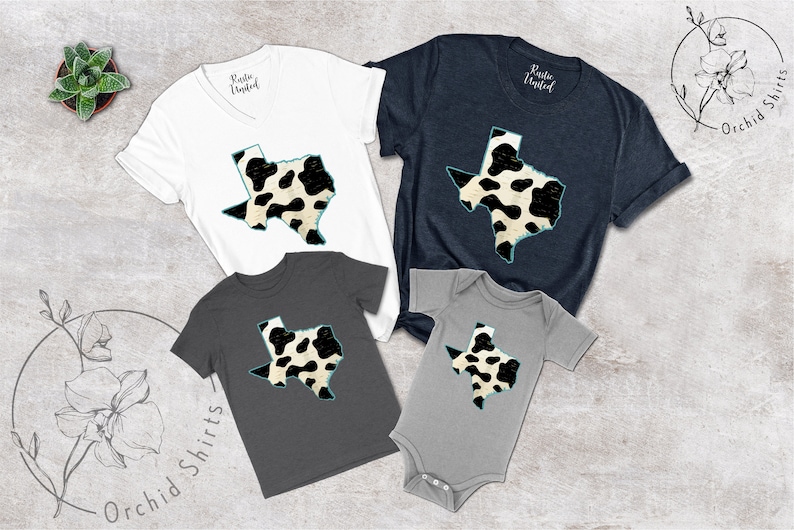 May include: A set of four shirts featuring a black and white cow print design of the state of Texas. The shirts are in various sizes and colors, including white, navy blue, and gray.