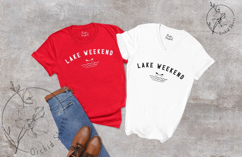 以下が含まれることがあります： 「LAKE WEEKEND」の文字とオールと波のグラフィックがプリントされた赤と白のTシャツ2枚。青いジーンズと茶色の革靴と組み合わせており、カジュアルなアウトドアをテーマにしていることを示唆しています。