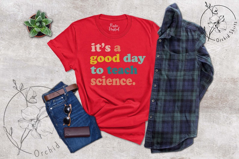 Op de afbeelding: Rood T-shirt met de tekst "it's a good day to teach science." in kleurrijk retro-lettertype.
