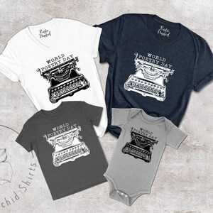 May include: A set of four shirts featuring a black and white illustration of a vintage typewriter with the text "World Poetry Day". The shirts are in various sizes and colours, including white, grey, dark grey, and navy blue.
