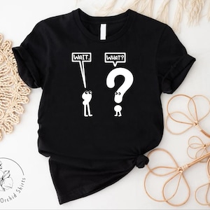May include: Black t-shirt with a white graphic of two stick figures. The figure on the left holds a sign that says "WAIT." The figure on the right holds a question mark and a sign that says "WHAT?"