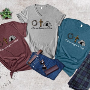 K&ouml;nnte beinhalten: Drei T-Shirts mit einem grafischen Design einer Dornenkrone, einem Kreuz und einem Grab. Der Text auf den T-Shirts lautet "A lot can happen in 3 days".