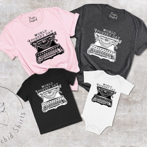 May include: A set of four t-shirts featuring a vintage typewriter graphic with the text "World Poetry Day". The shirts are in pink, grey, black, and white.