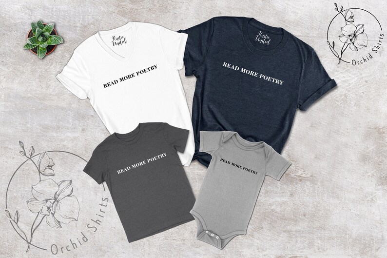 Op de afbeelding: Een set van vier shirts met de tekst "Read More Poetry" erop gedrukt. De shirts zijn in verschillende maten en kleuren, waaronder wit, donkergrijs en lichtgrijs. De shirts zijn gerangschikt op een lichtbruin, getextureerd oppervlak.
