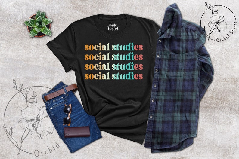 May include: Black t-shirt with the words "social studies" in a stacked design with retro-style lettering in orange, teal, white, pink, and orange. The shirt is paired with blue jeans, sunglasses, a brown wallet, a succulent, and a plaid shirt.