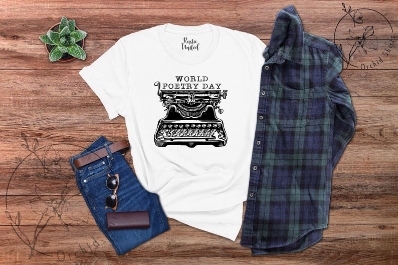 May include: White t-shirt featuring a black and white illustration of a vintage typewriter with the text "World Poetry Day".