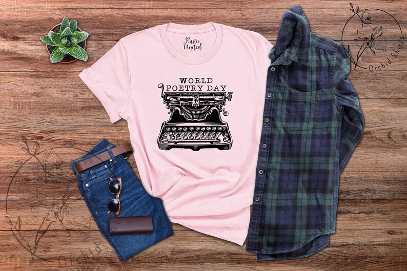 May include: A pink t-shirt featuring the text "WORLD POETRY DAY" and a vintage typewriter graphic.