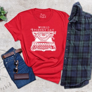 May include: Red t-shirt with a white graphic of a typewriter and the text "World Poetry Day".