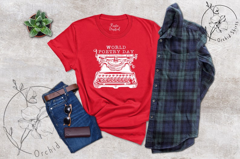 May include: Red t-shirt with a white graphic of a typewriter and the text "World Poetry Day".