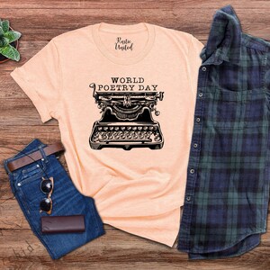 May include: A peach-coloured t-shirt with the text "World Poetry Day" and a vintage typewriter graphic.