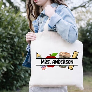 Może przedstawiać: Biała torba typu tote z czarno-białym nadrukiem oł&oacute;wka, jabłka, kubka do kawy i linijki. Na torbie nadrukowany jest tekst "MRS. ANDERSON".