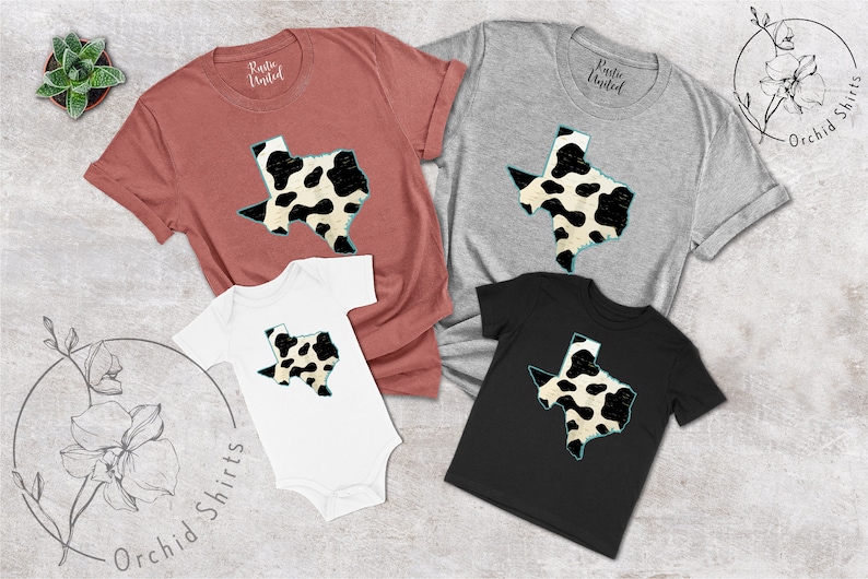 May include: A set of four shirts featuring a black and white cow print design of the state of Texas. The shirts are in various sizes and colors, including red, gray, white, and black.