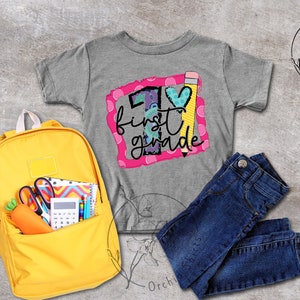 May include: A grey t-shirt with a pink and white graphic that says "1st grade" with a pencil and heart design. A yellow backpack with school supplies, a pair of blue jeans, and a grey background.