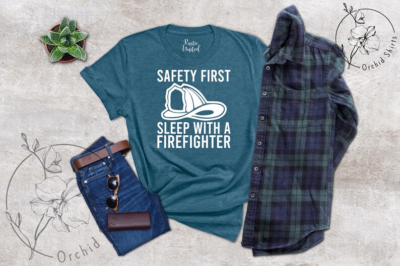 May include: A teal blue t-shirt with the text "Safety First Sleep with a Firefighter" and a white illustration of a firefighter's helmet.