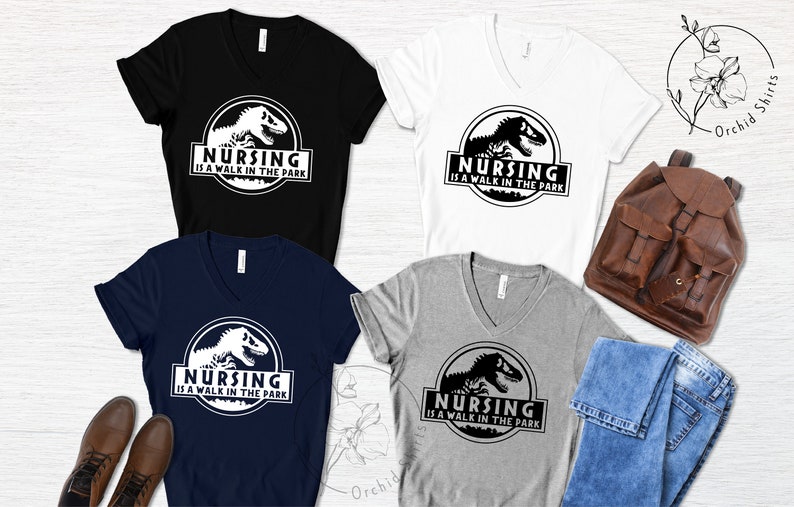 May include: Four V-neck t-shirts with a white dinosaur graphic and the text "Nursing is a walk in the park". The shirts are in black, navy blue, white, and heather gray.