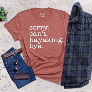 May include: A rust-colored t-shirt with the text "sorry. can't. kayaking. bye." in white lettering.