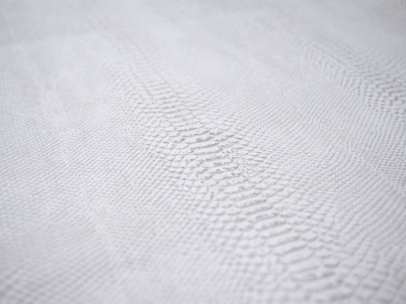 May include: White textured fabric with a subtle snake skin pattern.