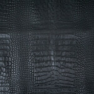 May include: Black crocodile embossed leather texture. The surface has a repeating pattern of scales.
