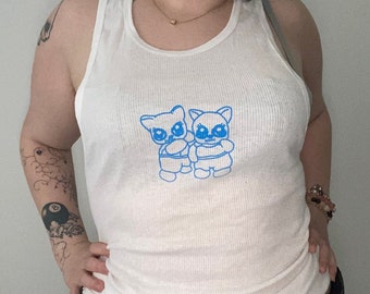 May include: White ribbed tank top with a blue graphic of two cartoon bears holding hands.