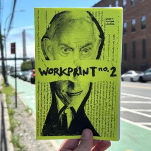 May include: A hand holds a magazine titled "WORKPRINT no. 2." The cover is bright yellow with a black and white image of a man's face. The magazine has text in black and white, with the words "MISFIT CINEMA JOURNAL" visible.