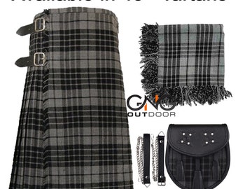 Puede incluir: Un kilt de tartán gris y negro con correas y hebillas de cuero, una bufanda a juego con flecos, un sporran y correas de cadena. El texto "Available in 45+ Tartans" está en la parte superior.
