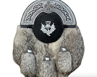 Può includere: Uno sporran da kilt argentato e nero con un emblema di cardo e quattro nappe di pelliccia grigia.