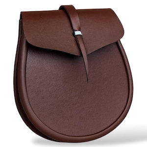 May include: A brown leather bag with a curved, rounded bottom and a flap closure. The bag has a strap with a silver-colored metal accent. The bag is made of a textured leather material.