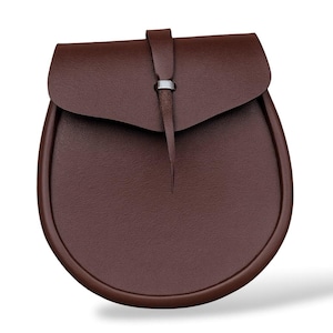 May include: A brown leather sporran with a rounded bottom and a flap closure. The flap is secured with a leather strap and a silver-colored metal ring. The sporran has a textured surface.