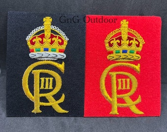 May include: Two embroidered patches with a gold crown and the letters "C R III" in gold thread. The patch on the left is on a black background and the patch on the right is on a red background.