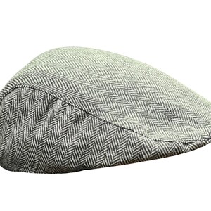 Puede incluir: Una gorra plana de color gris y blanco con un patrón de espiga.