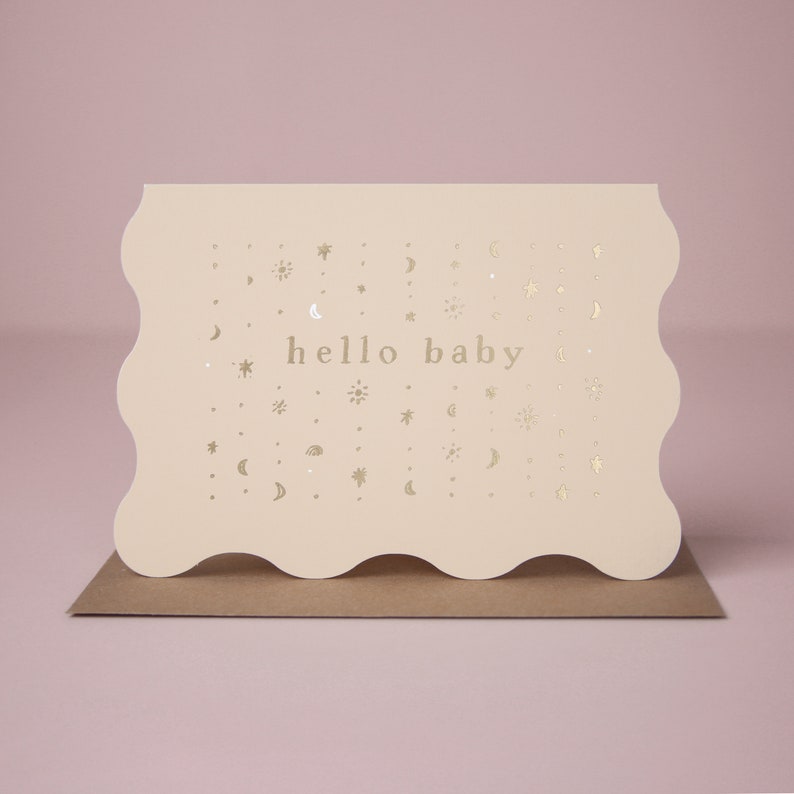 The twinkling pattern of gold foil stars and moons welcomes a unisex new tiny human to the world on this gender neutral new baby card.