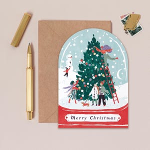 A jolly holiday scene is enclosed in a snowglobe on this uniquely shaped Christmas greeting card, inspired by the beautiful memories we make when spending time with loved ones every year. Trimming the tree, building snowmen, and enjoying the festivities together - there's no doubt that makes for a Merry Christmas. This illustrated Christmas greeting card from UK based brand Sister Paper Co is part of a collection of cards featuring unique shapes and intricate hand-painted designs.
