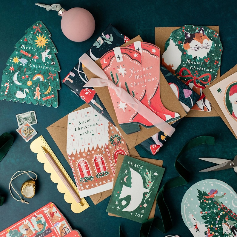 A jolly holiday scene is enclosed in a snowglobe on this uniquely shaped Christmas greeting card, inspired by the beautiful memories we make when spending time with loved ones every year. Trimming the tree, building snowmen, and enjoying the festivities together - there's no doubt that makes for a Merry Christmas. This illustrated Christmas greeting card from UK based brand Sister Paper Co is part of a collection of cards featuring unique shapes and intricate hand-painted designs.