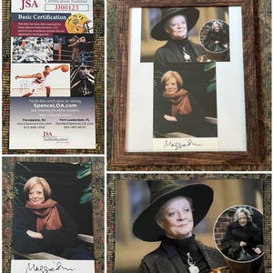 May include: A framed photo of an actress wearing a black robe and a black witch hat. The photo is signed "Maggie Smith".