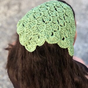 Puede incluir: Un cubrecabezas de ganchillo verde claro con un borde festoneado. El cubrecabezas est&aacute; hecho de un hilo texturizado y se usa en la cabeza. El cubrecabezas es un accesorio elegante.